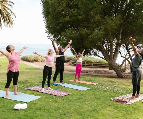 Group of diverse students relaxing on yoga mats.